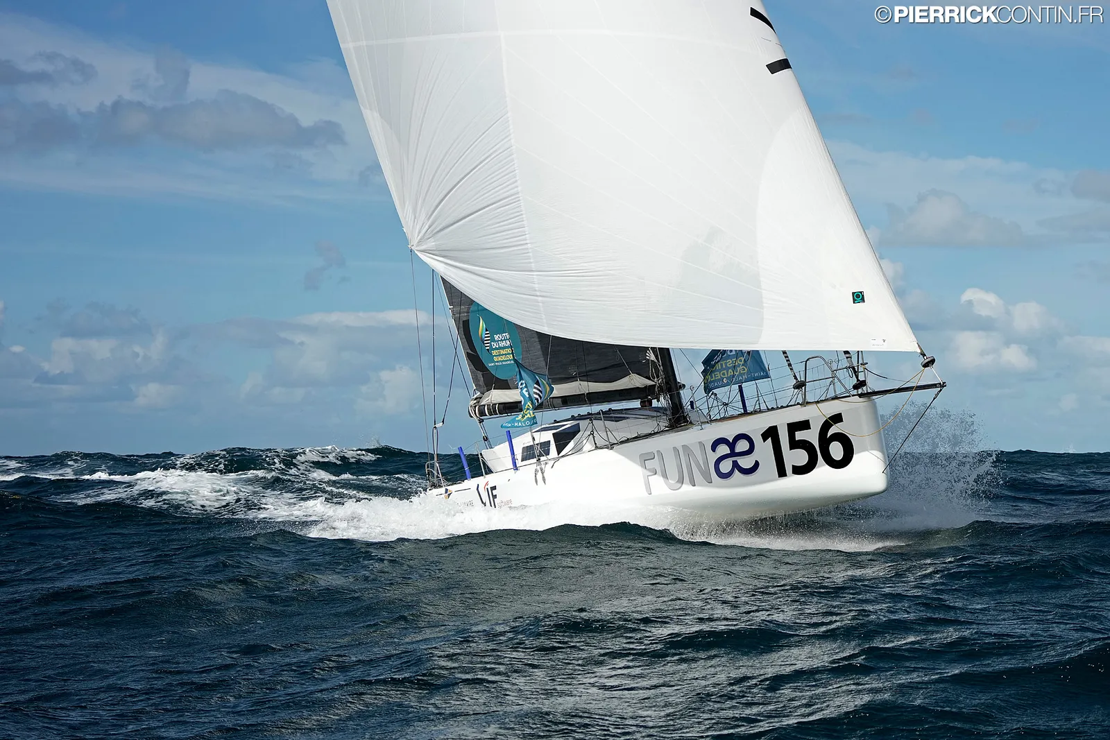 Le Class40 sous voile d'avant blanche, lancé dans la houle