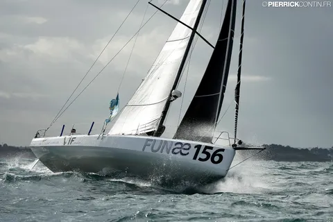 Le Class40 sous voiles claires, les embruns sur l'étrave