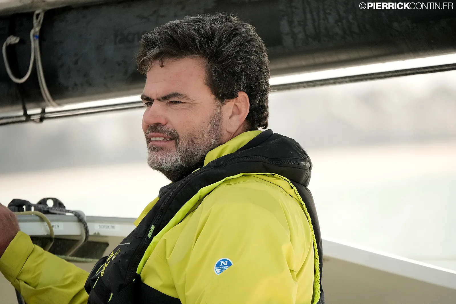 Loïc Féquet de profil, en ciré jaune et gilet de sauvetage, le regard tourné vers l'avant